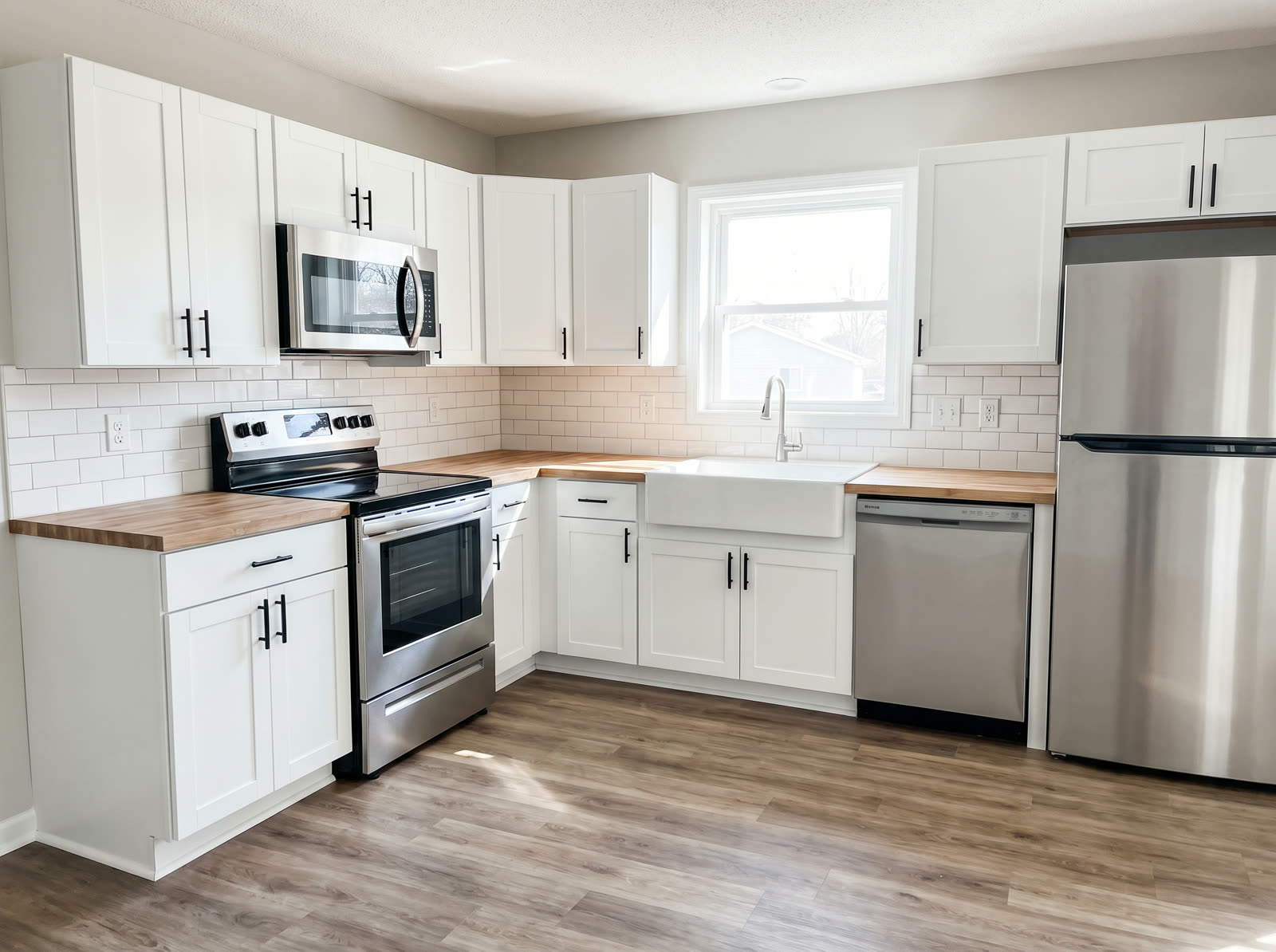 Clean, budget-conscious rental property kitchen remodel with white cabinets and stainless appliances