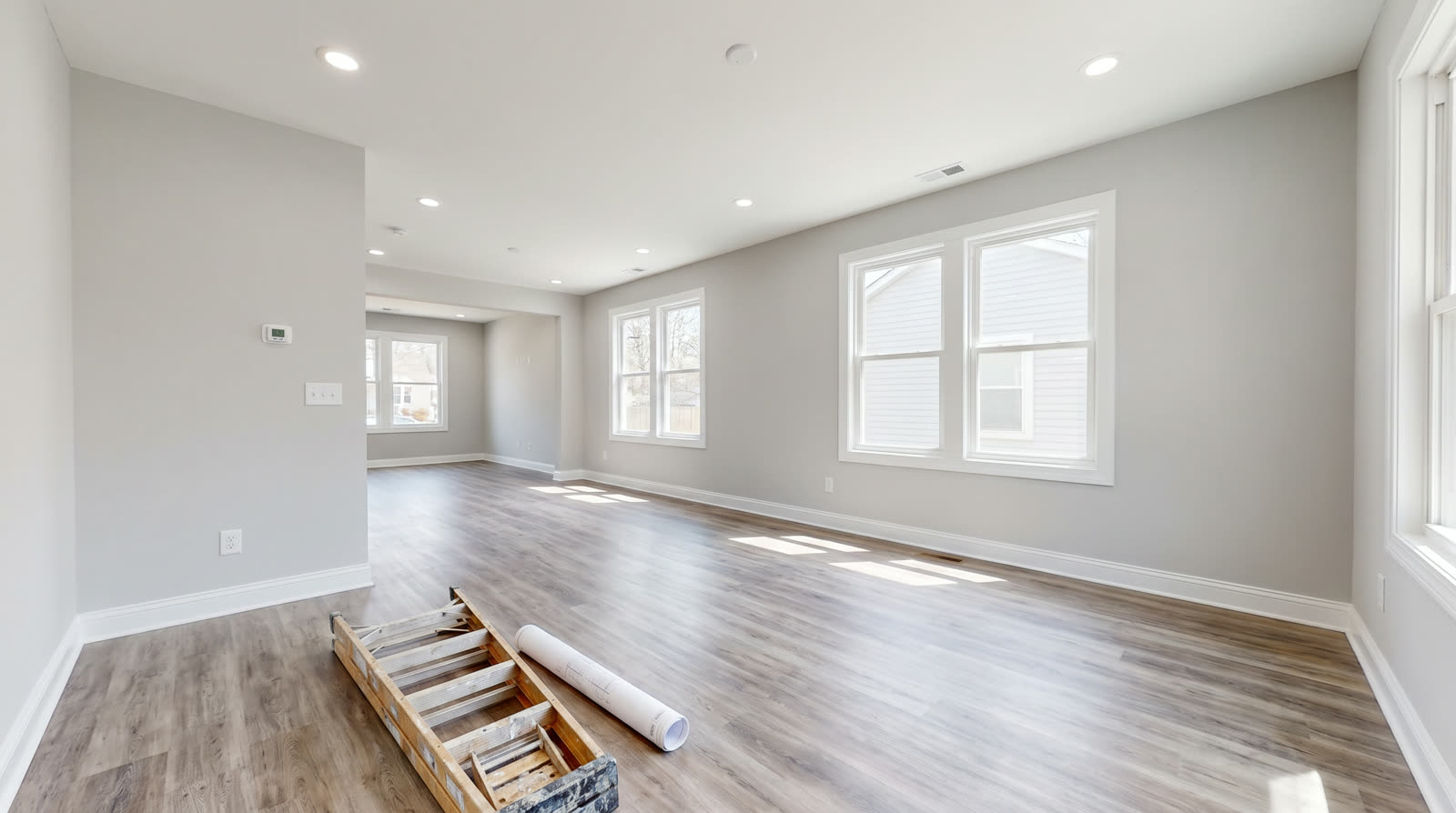 Freshly renovated open-concept living space in a flip property with new flooring and paint